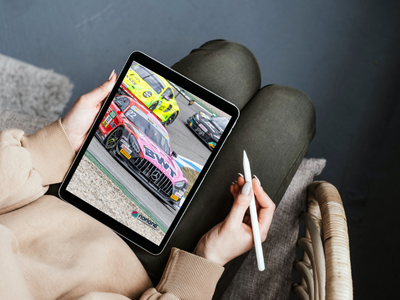 Frau mit Tablet auf dem ein DTM Auto zu sehen ist