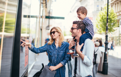 Familie steht an einem Fahrzeug einer Roadshow und informiert sich